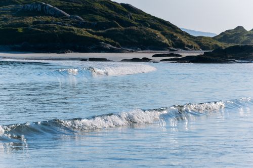 Free Serene coastal scene in Ireland with gentle ocean waves lapping against the shore. Stock Photo