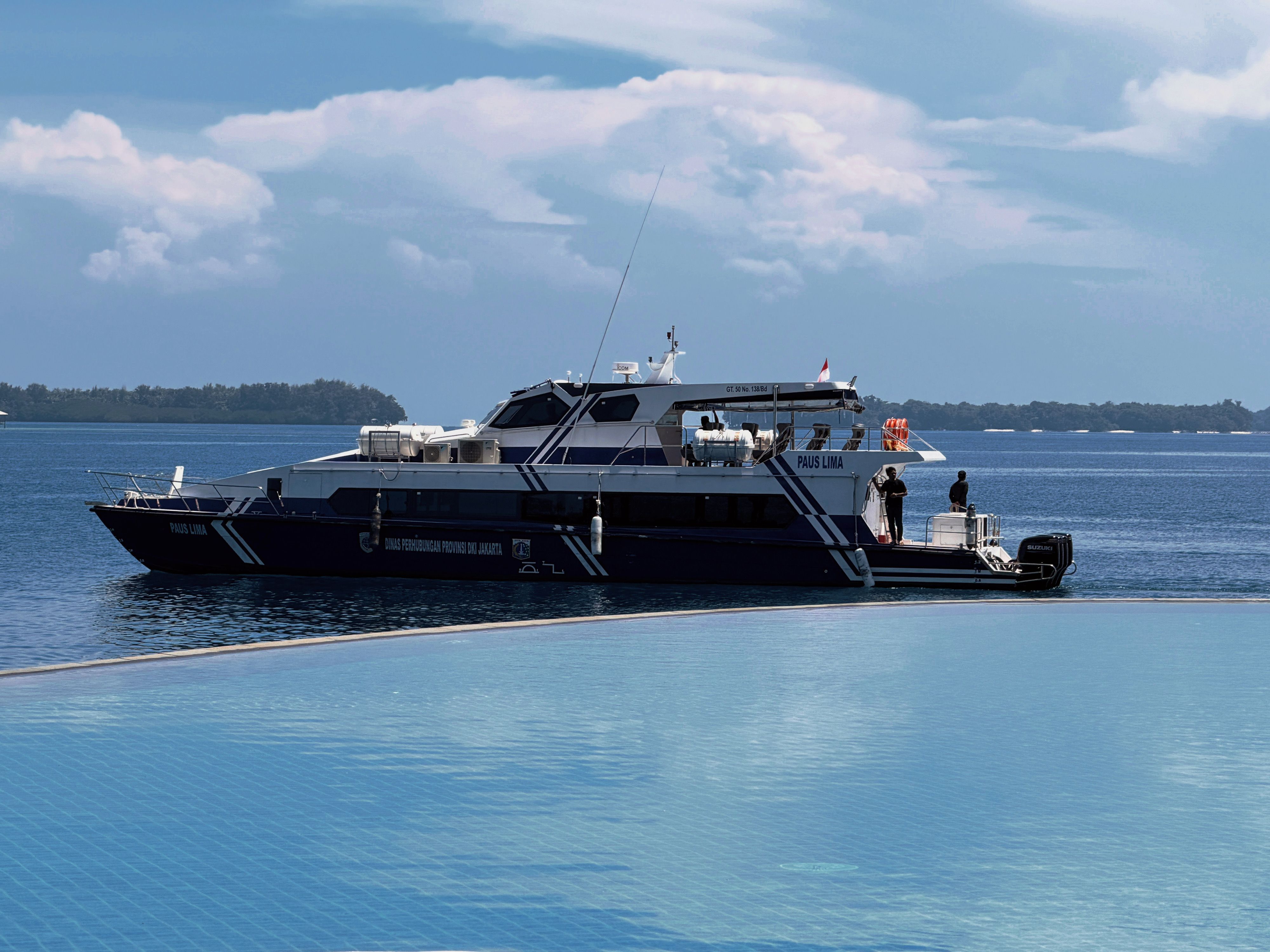 Explore Jakarta's beautiful coastline with this ferry cruising through calm, blue waters under a clear sky.
