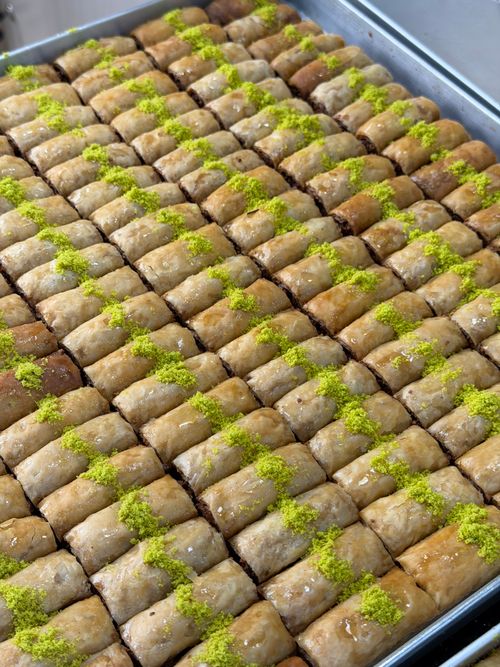 Free A large tray of delicious pistachio baklava, freshly baked and ready to serve, showcasing Middle Eastern culinary excellence. Stock Photo