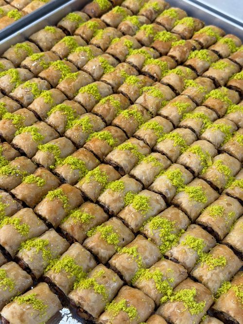 Free A tray filled with freshly made pistachio baklava, showcasing flaky pastry and green nut garnish. Stock Photo