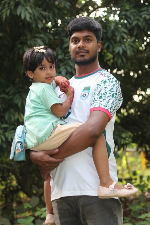 Free A father lovingly holding his daughter outdoors during a summer day. Stock Photo