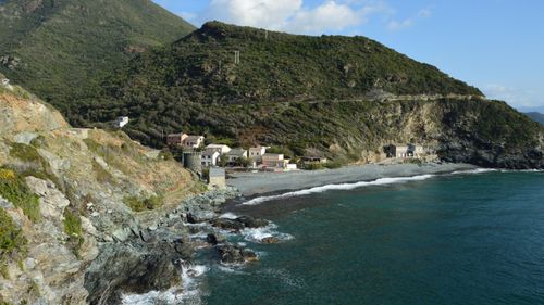 Free A beautiful coastal village nestled in the hills of Olmeta-di-Capocorso, Corse, France, with rocky shores and lush greenery. Stock Photo