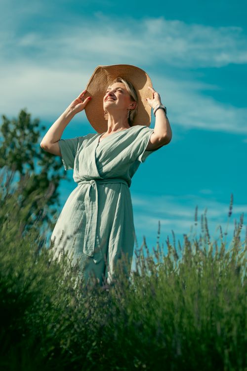 Free Content woman in sun hat enjoying a sunny day in a lavender field, embodying relaxation and nature. Stock Photo