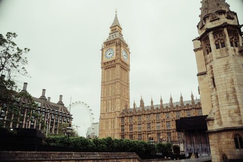 Free A scenic view of Big Ben, the Houses of Parliament, and the London Eye on an overcast day. Stock Photo