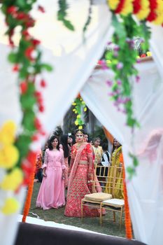 A beautiful Indian bride in traditional attire during an outdoor wedding ceremony, showcasing cultural elegance.