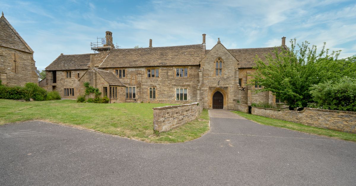 Charming stone manor with old-world architecture amidst lush greenery.