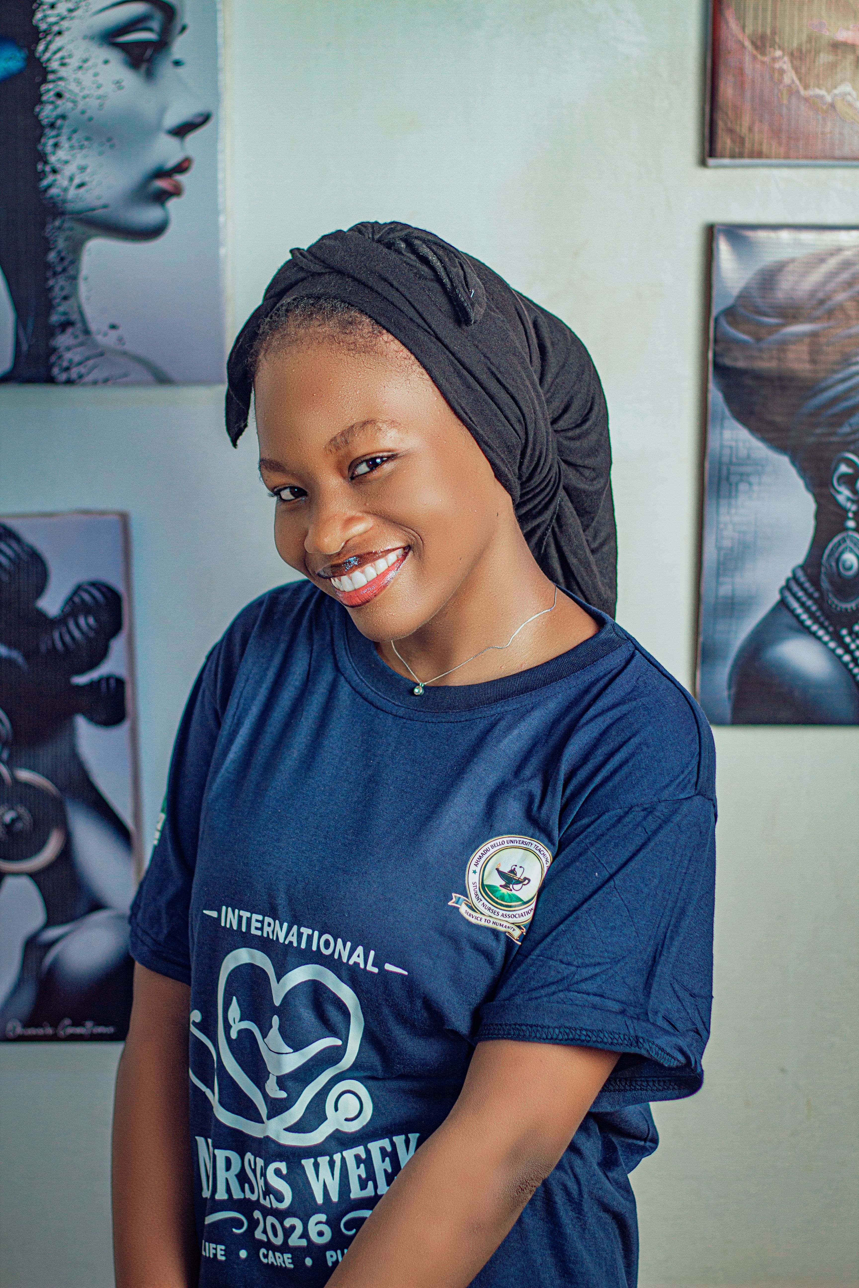 Woman smiling indoors with artistic decor and head wrap