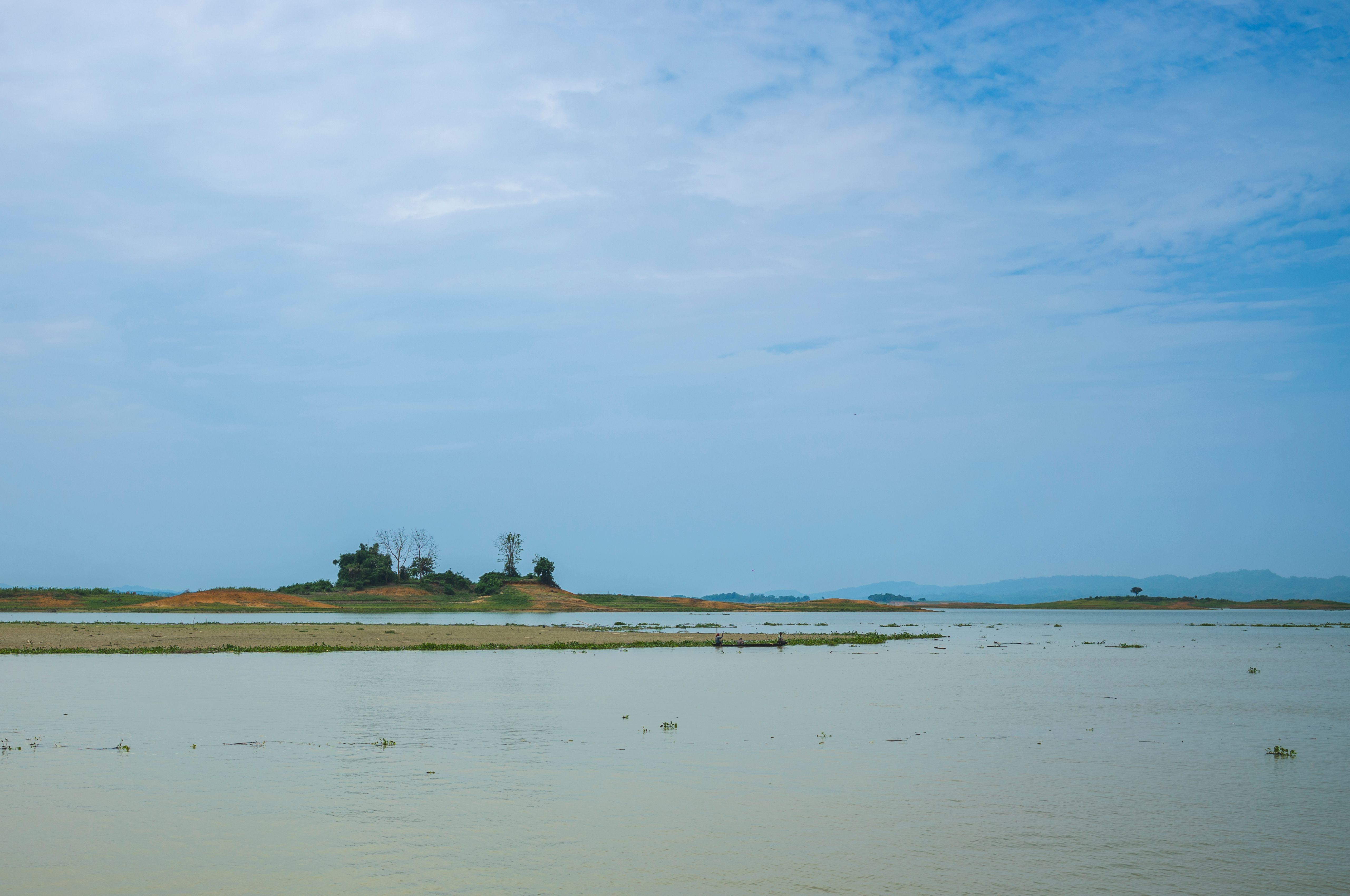 Tranquil view of a lake with an island under a blue sky, perfect for nature lovers.