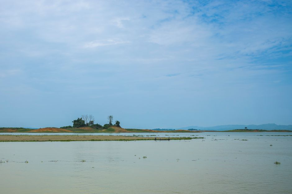 Tranquil view of a lake with an island under a blue sky, perfect for nature lovers.