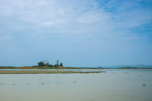 Free Tranquil view of a lake with an island under a blue sky, perfect for nature lovers. Stock Photo