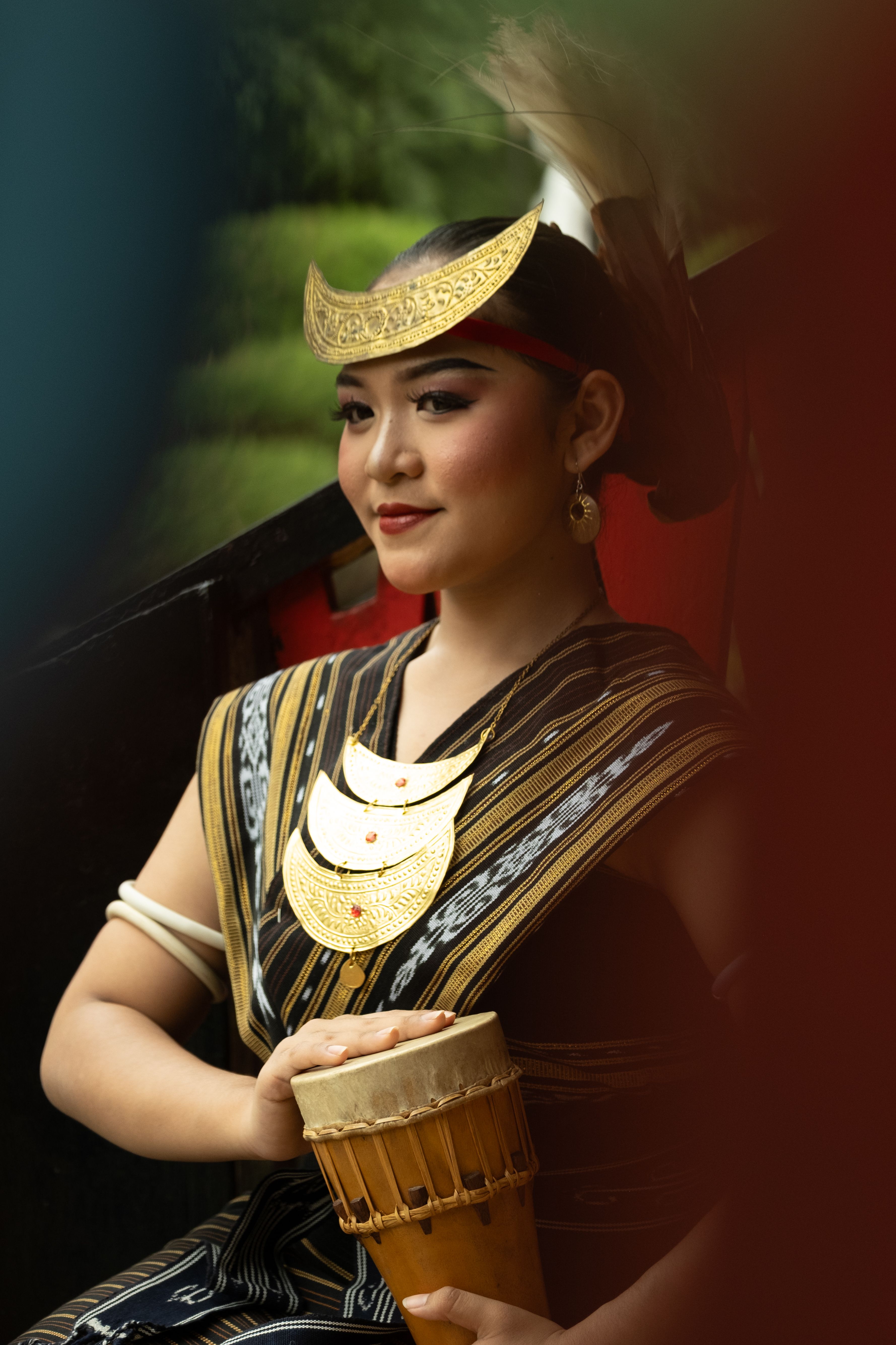 Portrait of a woman in traditional Indonesian attire with cultural accessories.