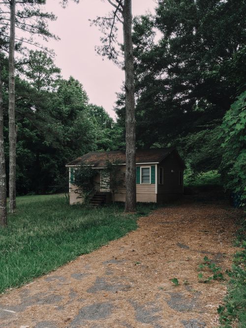 Free Cozy cabin nestled in a green forest setting, perfect for retreats and nature escapes. Stock Photo