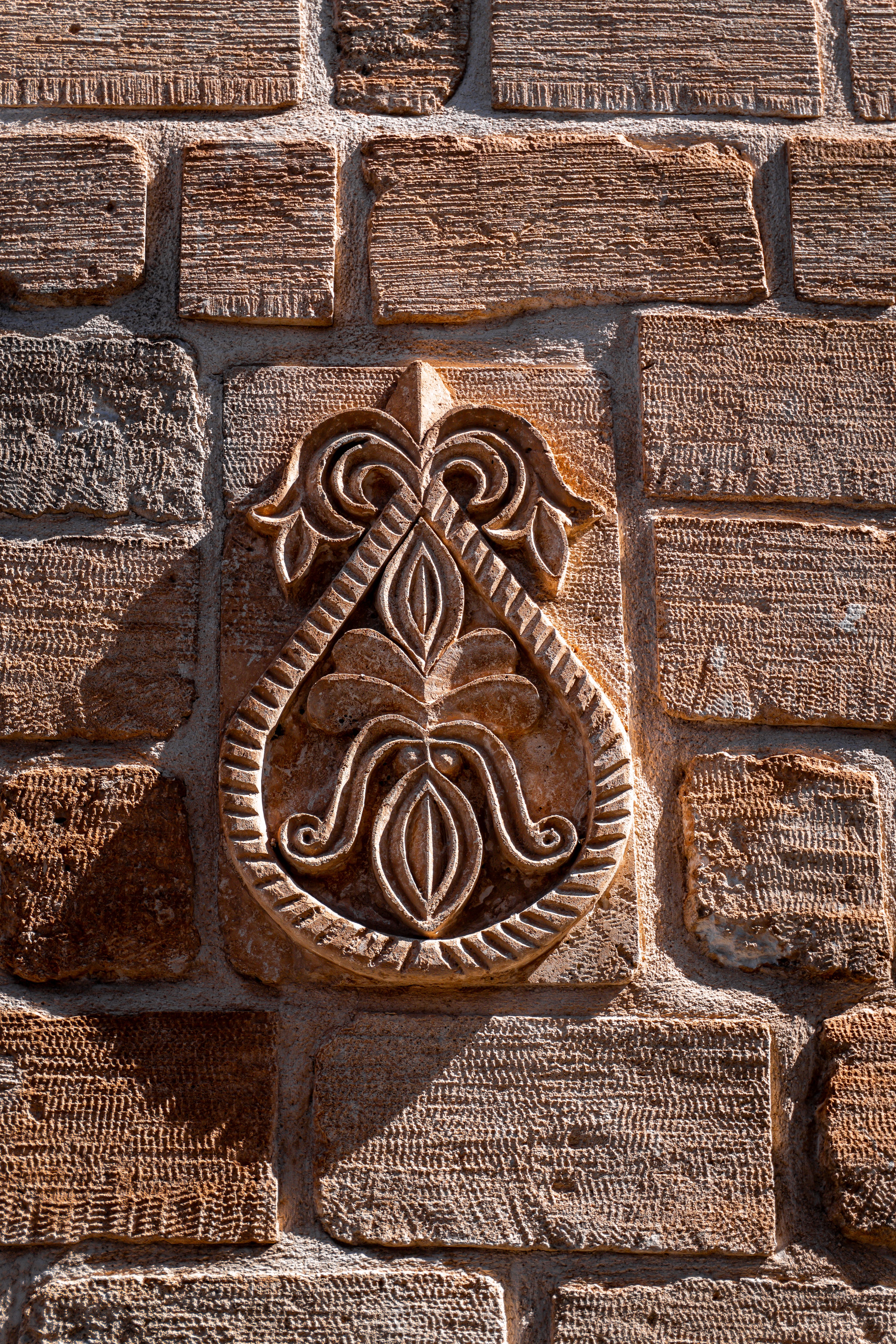 Detailed stone carving on an ancient wall in Mardin, Türkiye highlighting intricate craftsmanship.