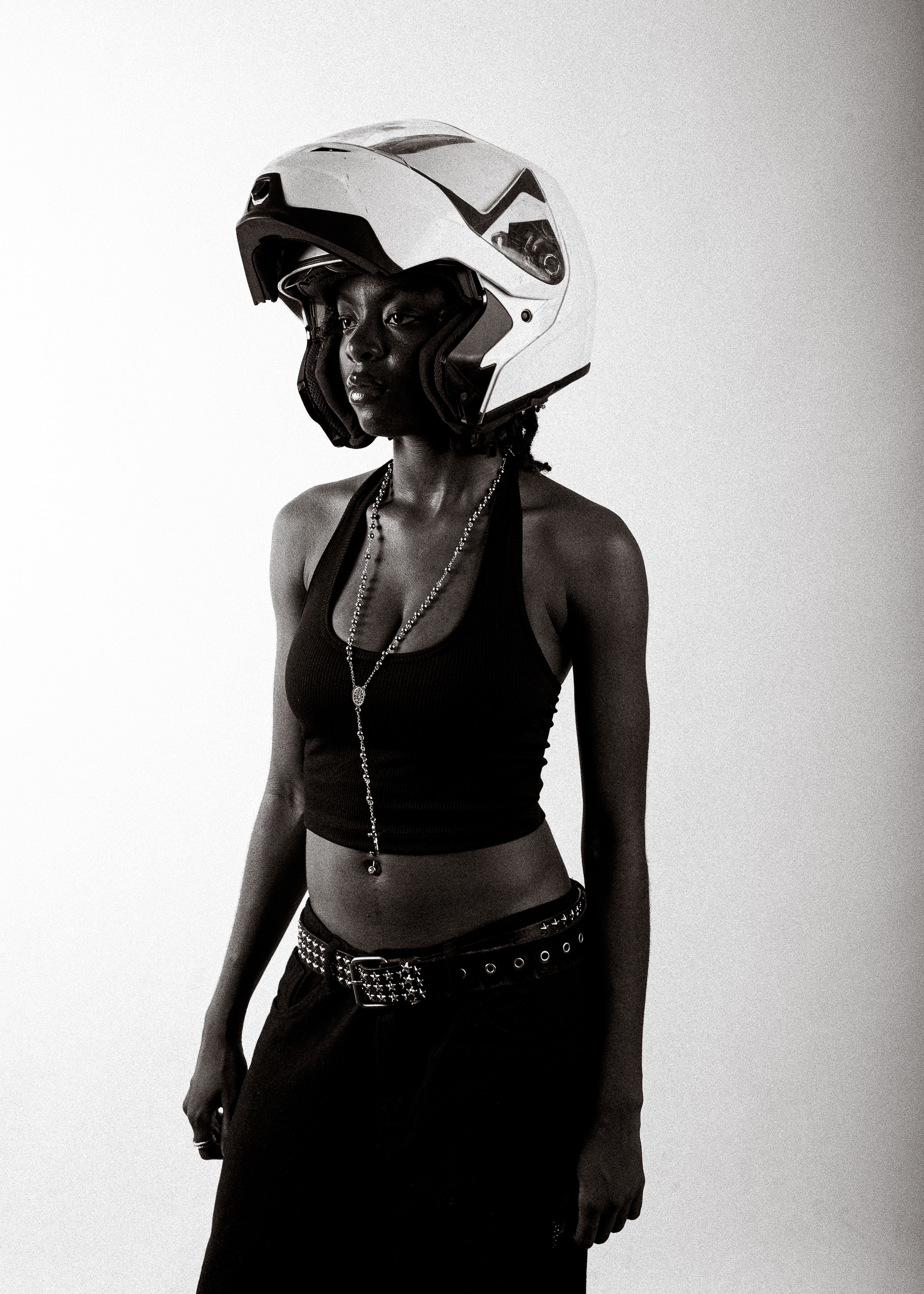 Monochrome portrait of a woman wearing a fashionable outfit and a helmet.