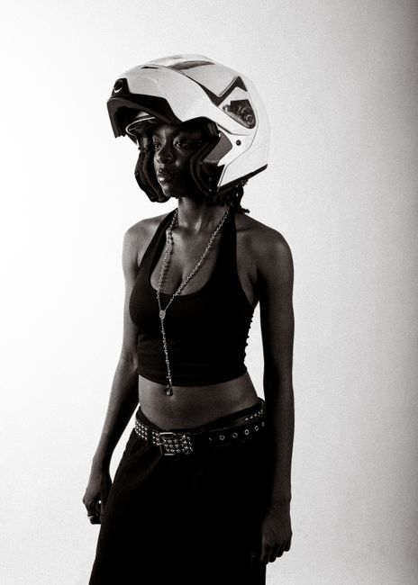 Monochrome portrait of a woman wearing a fashionable outfit and a helmet.