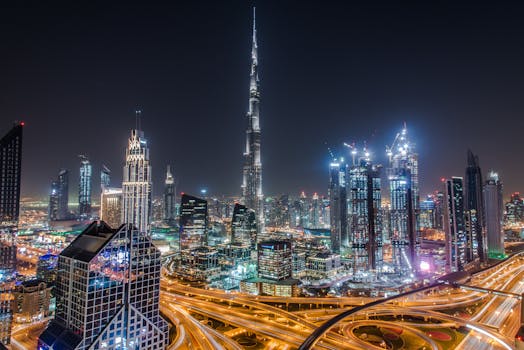 A stunning view of Dubai's illuminated skyline featuring the towering Burj Khalifa at night.