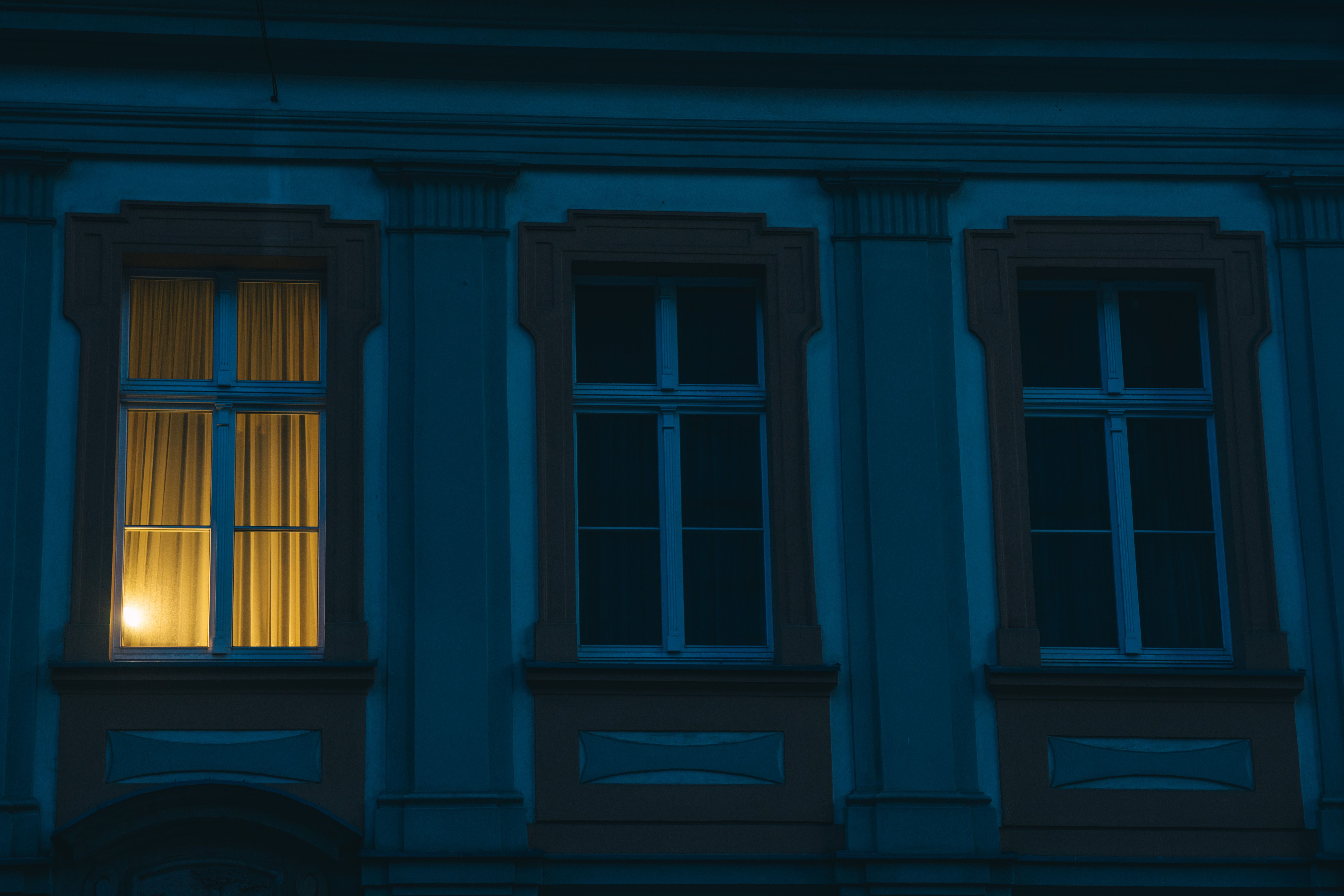 A building facade in Wroclaw with a single illuminated window during nighttime.