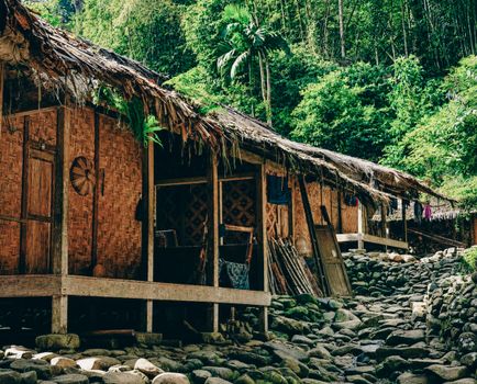 Charming bamboo houses with thatched roofs nestled in lush greenery in Banten, Indonesia.