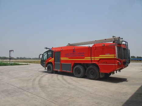 Red airport fire truck on an airstrip, operated by Airports Authority of India.
