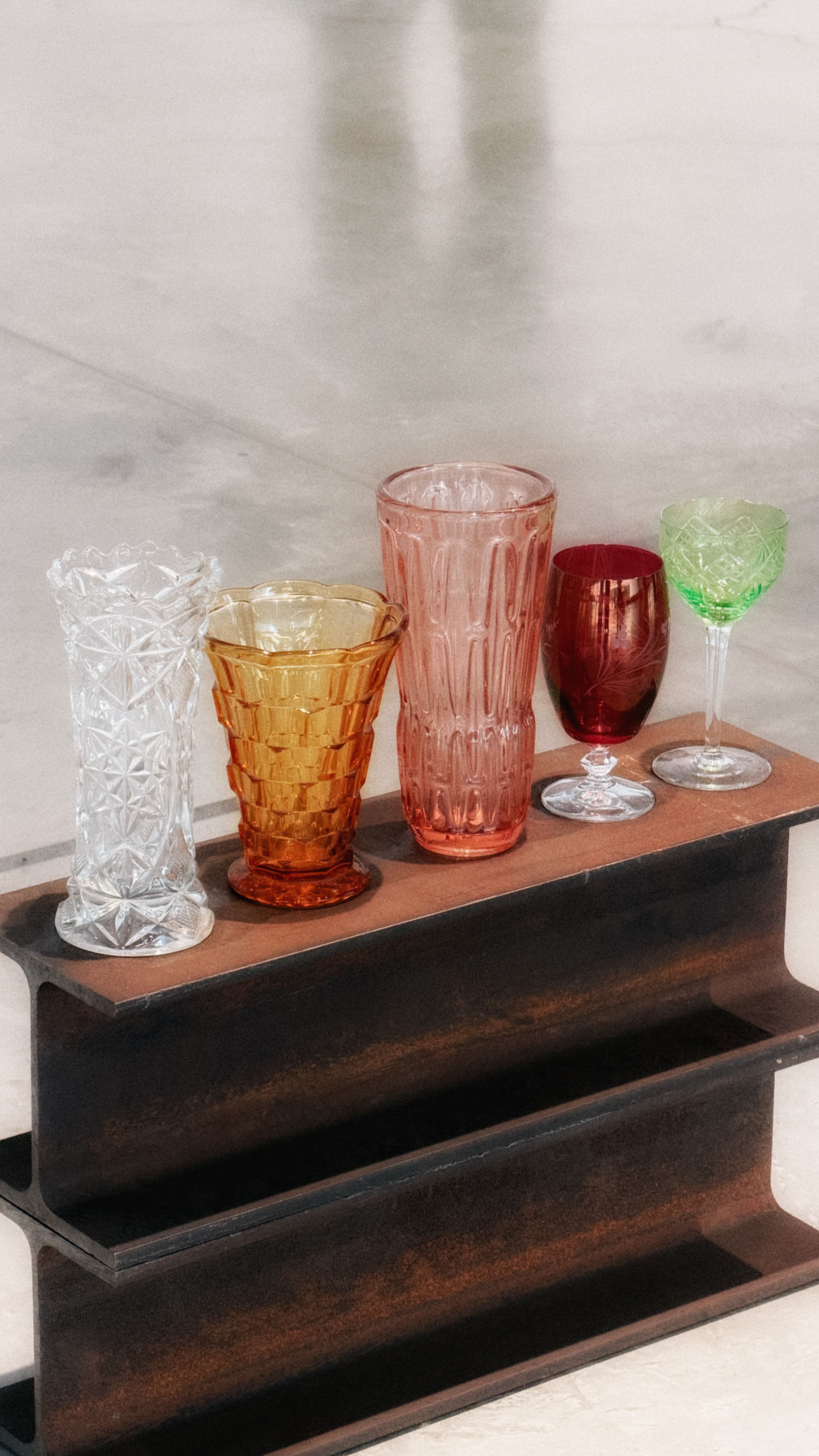 Free A collection of five colorful vintage glasses on a wooden shelf, showcasing intricate designs. Stock Photo