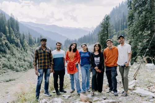 Free A diverse group of friends smiling in a lush mountainous landscape during daytime. Stock Photo