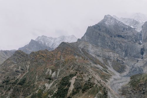 Free Scenic view of rugged mountain range with snow capped peaks and lush valleys. Stock Photo