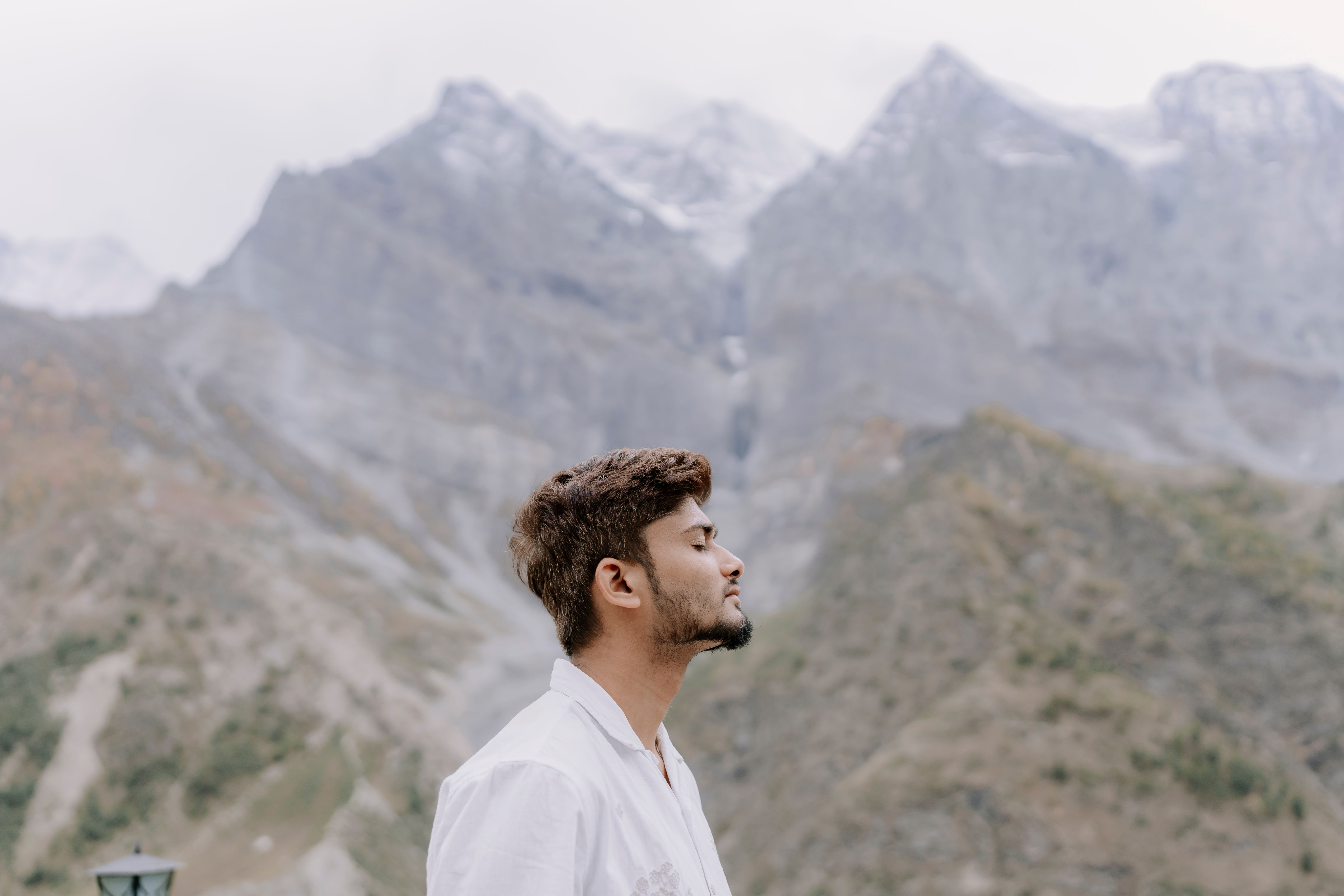 Young man enjoying the serene mountain landscape, embracing nature.