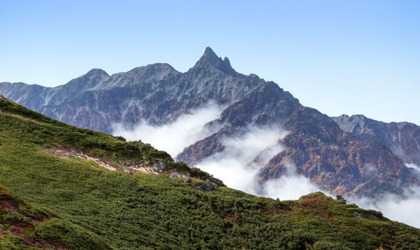 Majestic view of the Japanese Alps with clouds hovering over Enzanso peaks in autumn.