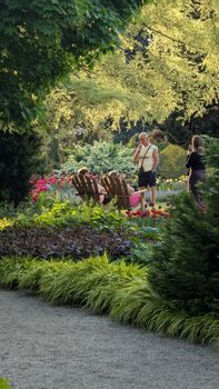 People enjoying a sunny day in a beautiful and vibrant garden landscape.