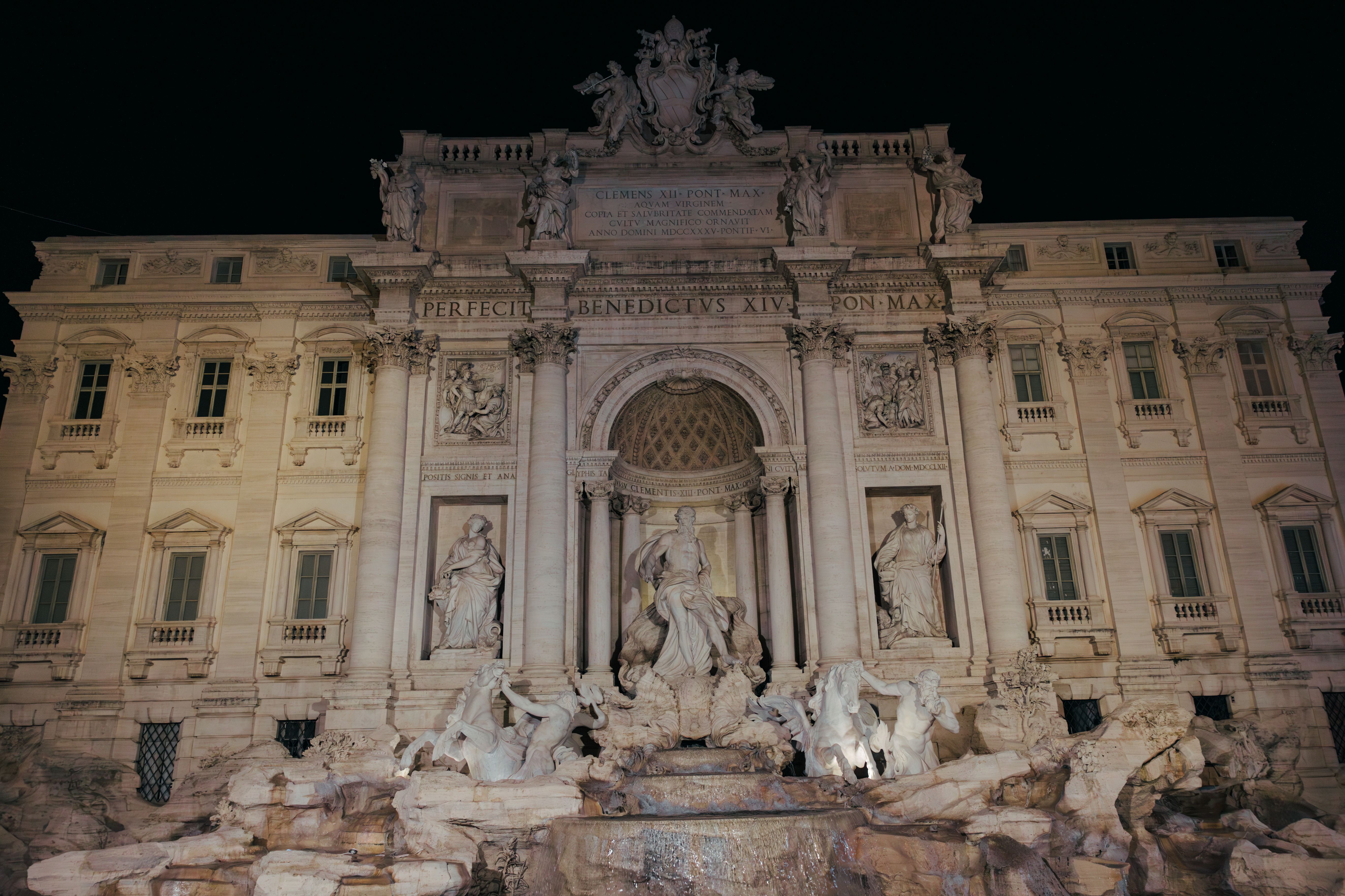 Tourists drinking from a Nasoni public fountain in Rome during summer