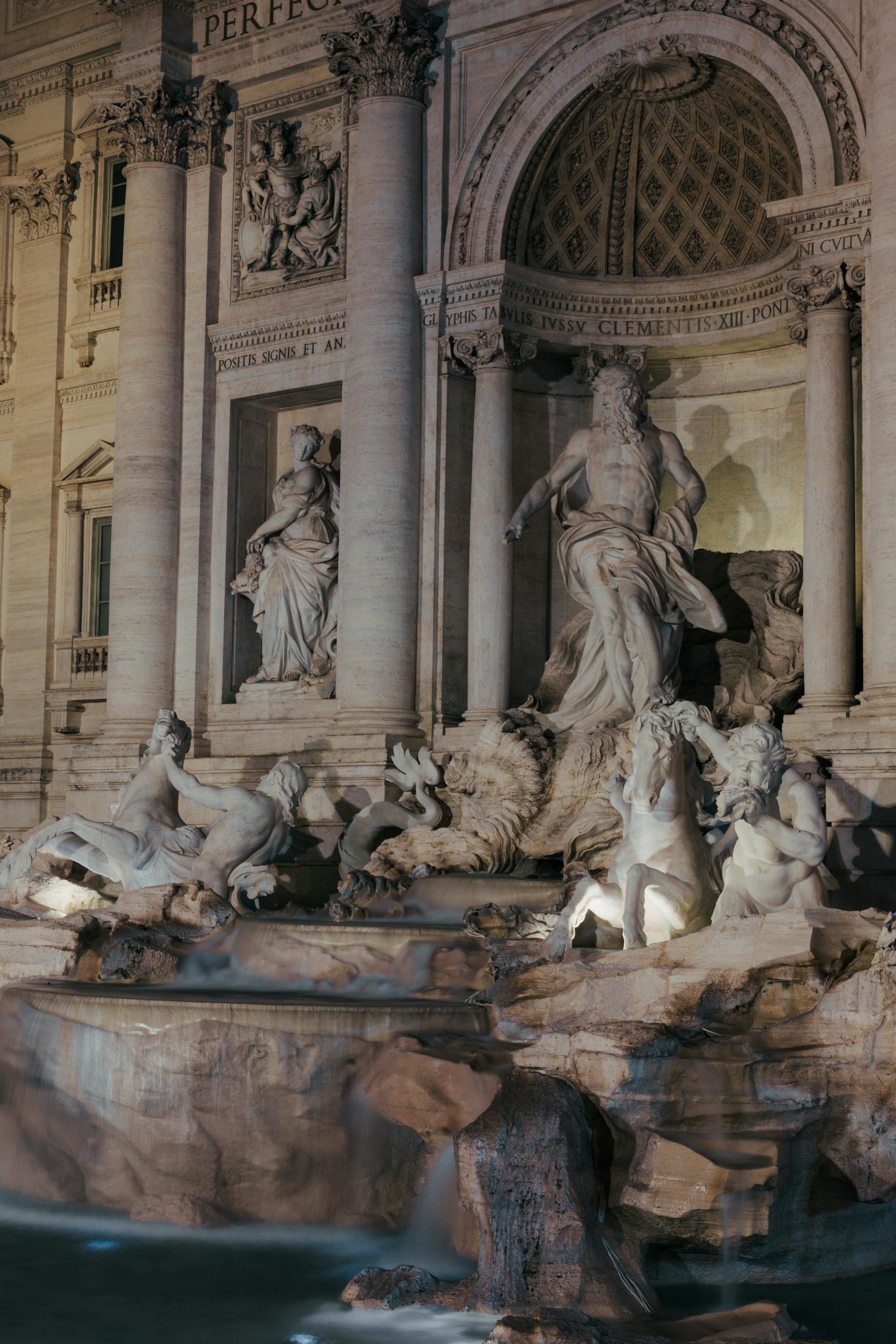 Beautifully lit Trevi Fountain in Rome captured at night, showcasing its stunning sculptures and architecture.