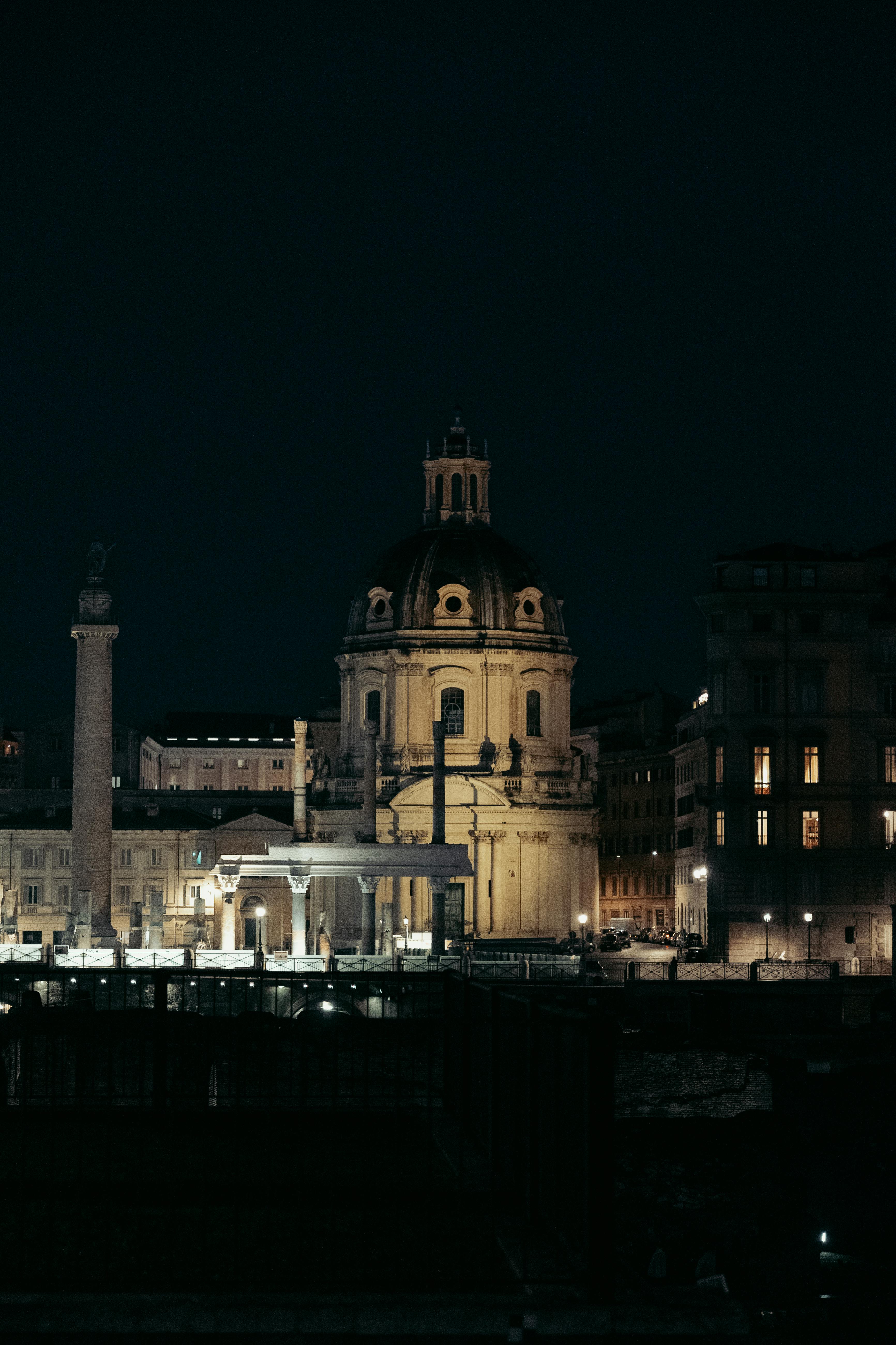 Night view of iconic Roman architecture with domed rooftop, beautifully illuminated against the dark sky.