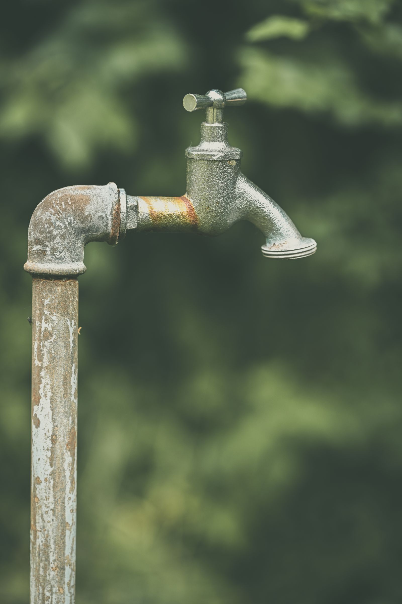A close up of a weathered metal outdoor water faucet and pipe. — How much does drain cleaning cost in Ocala? — Johnson Brothers Plumbing, Ocala