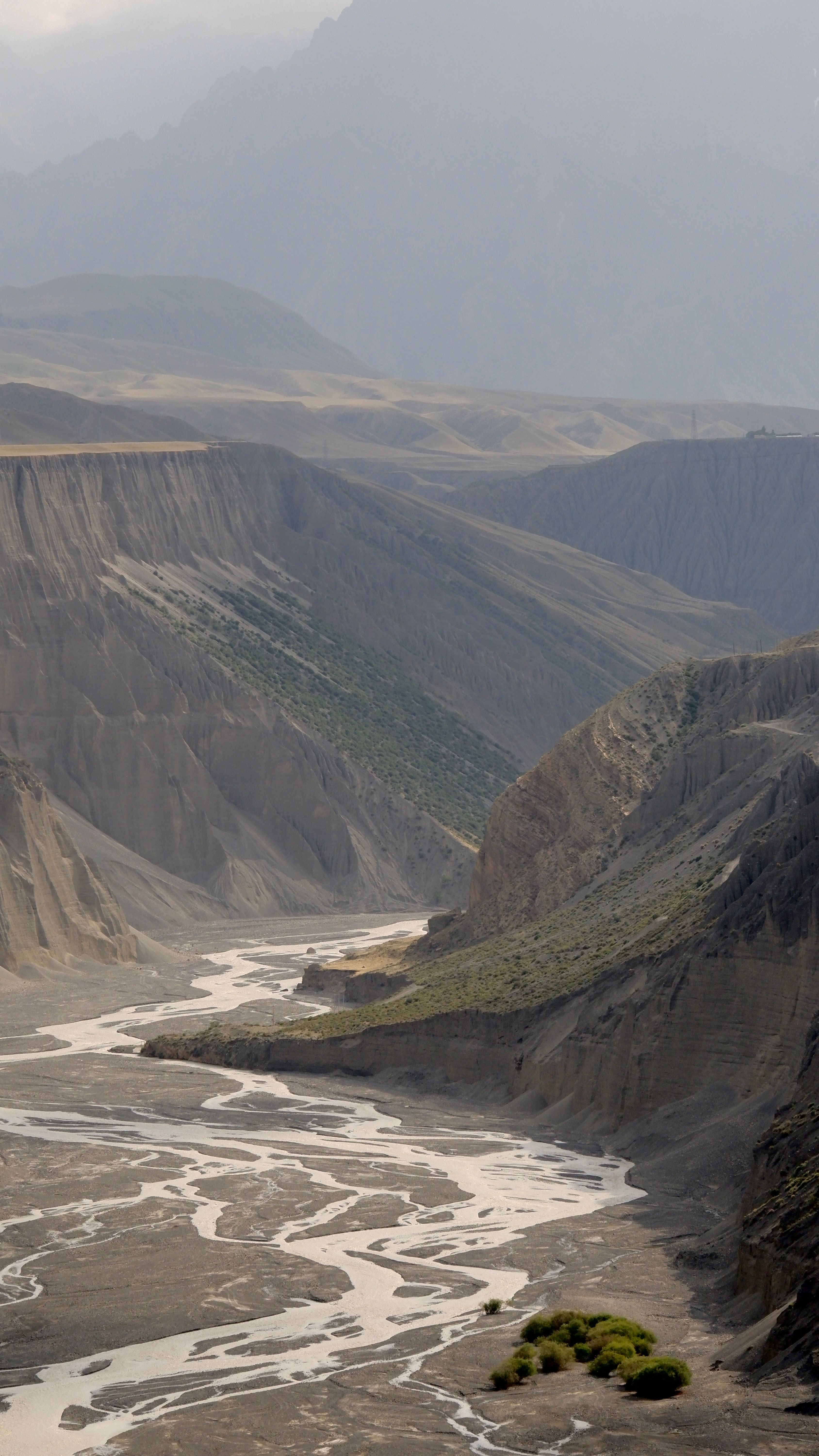 Stunning view of meandering river through canyon in Xinjiang's Tianshan mountain range.