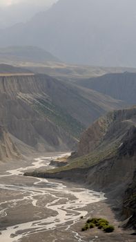 Stunning view of meandering river through canyon in Xinjiang's Tianshan mountain range.