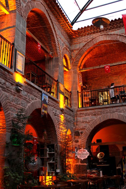Free A warm-lit historic Ottoman archway interior with intricate brickwork and flags. Stock Photo