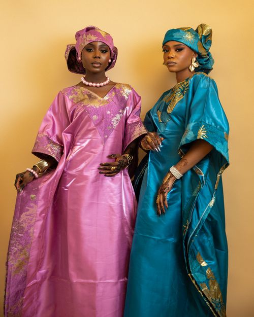 Free Two women in vibrant traditional Nigerian dresses with henna designs. Stock Photo