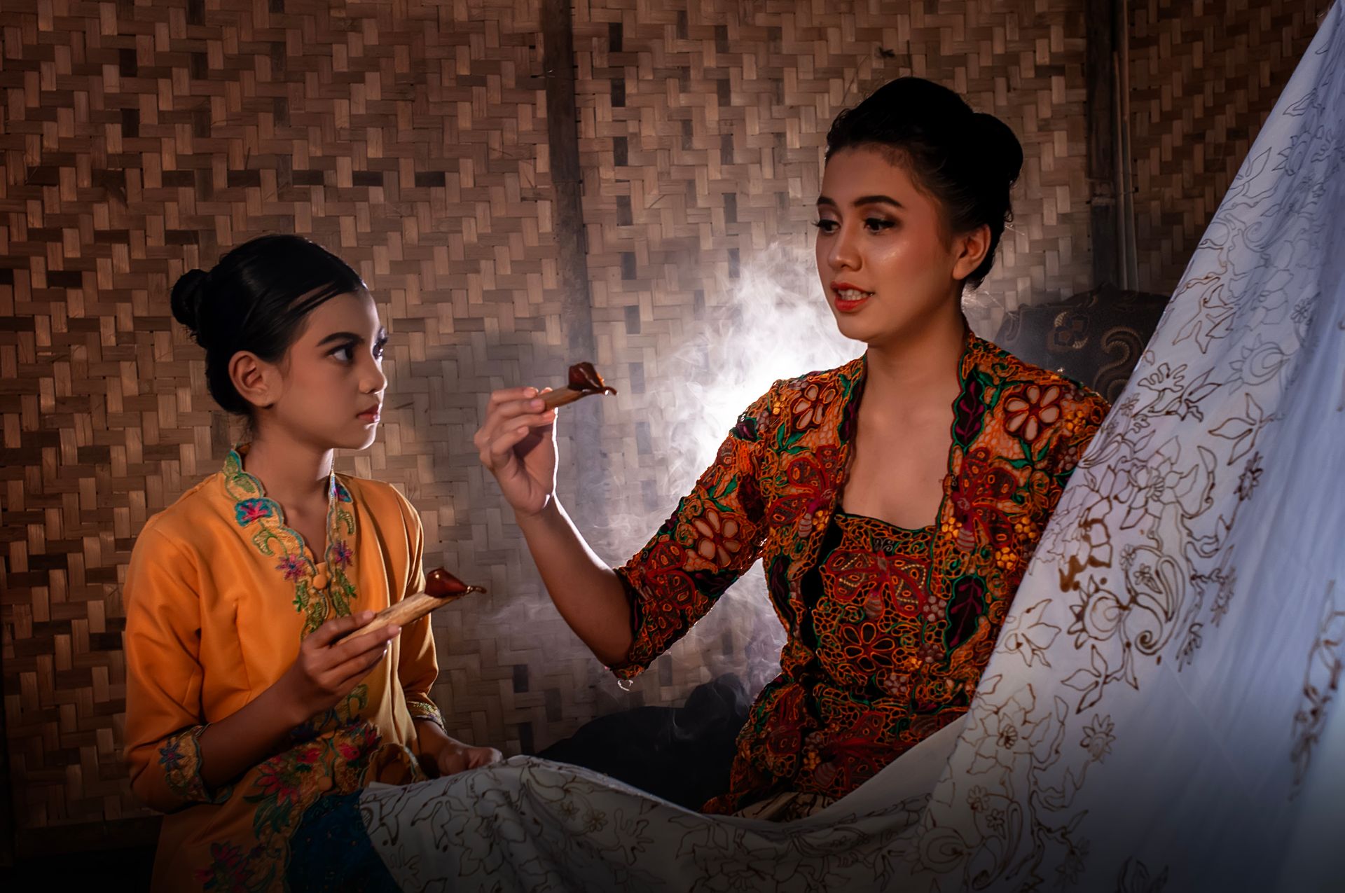 Mother and daughter engaged in traditional batik making, showcasing Indonesian heritage.