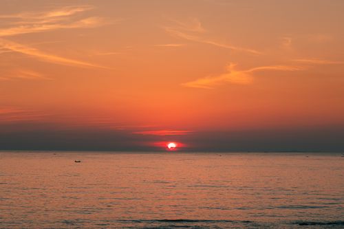 Free A breathtaking sunset over the ocean at Cửa Tùng, Vietnam with vibrant orange and pink hues. Stock Photo