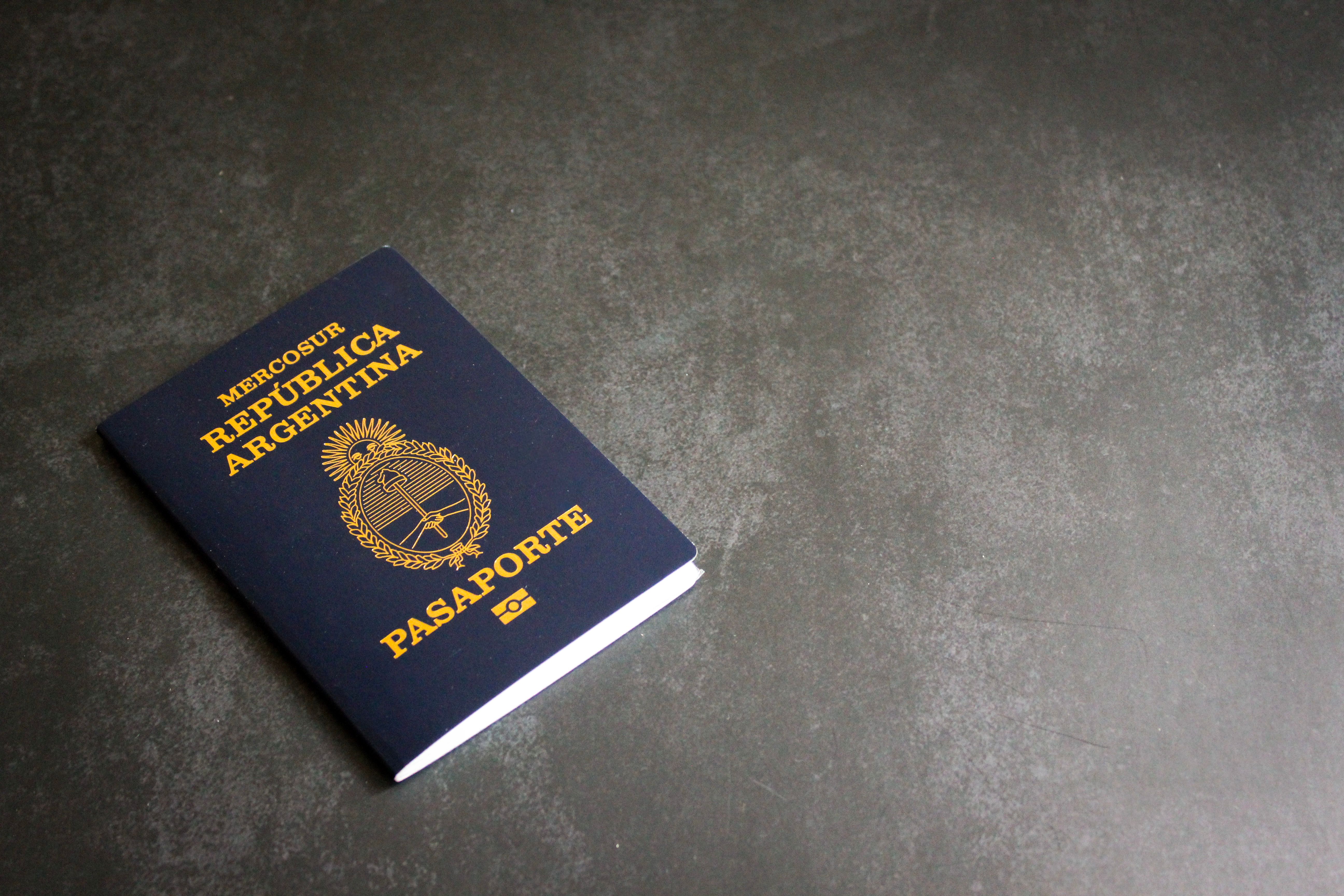 High-quality image of an Argentinian passport on a dark slate background, ideal for travel themes.