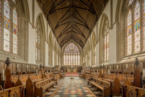 Free The stunning interior of Merton College Chapel featuring stained glass windows and wooden pews in Oxford, UK. Stock Photo