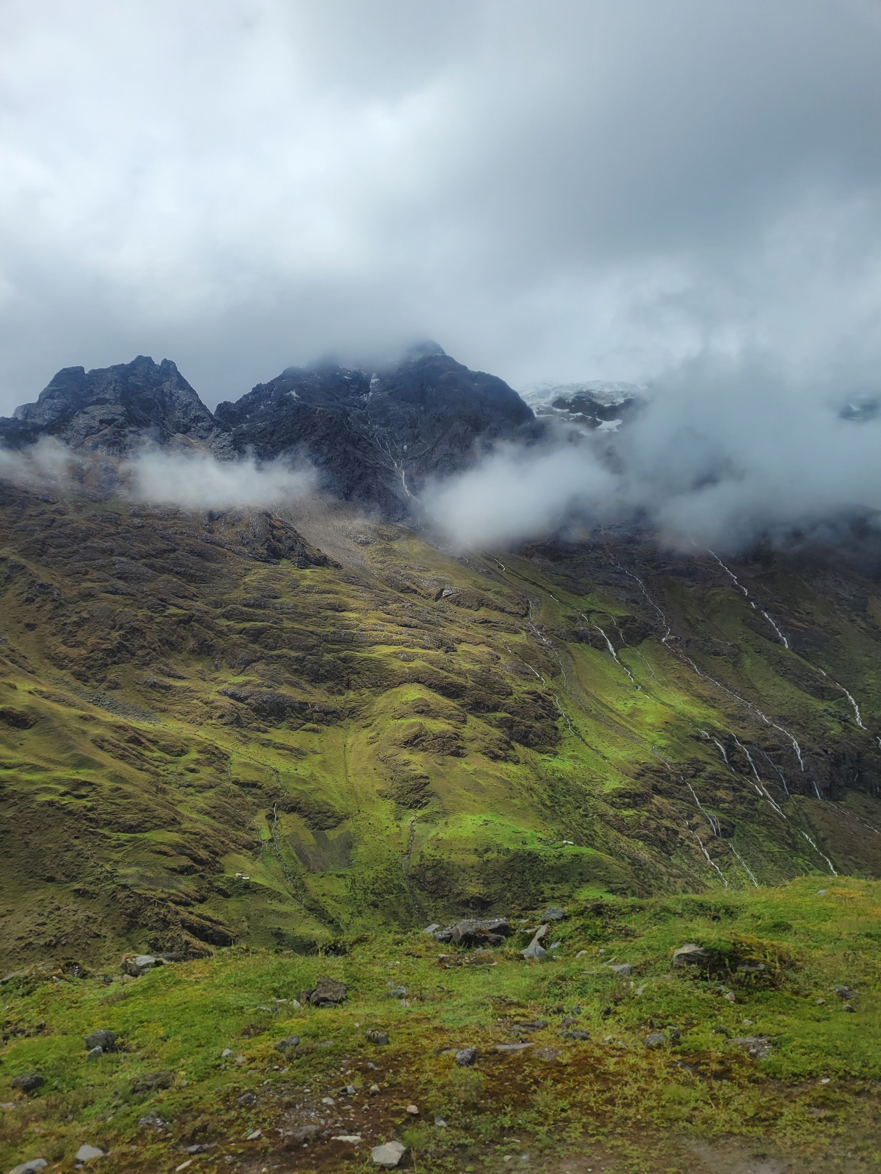 Breathtaking view of lush green mountains covered in mist and clouds in the Peruvian Andes.