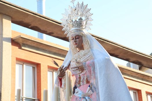 A religious statue of the Virgin Mary during a procession in El Puerto de Santa María, Spain.