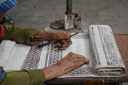 Close-up of Hmong artisan weaving traditional textile in Lung Tam Vietnam.