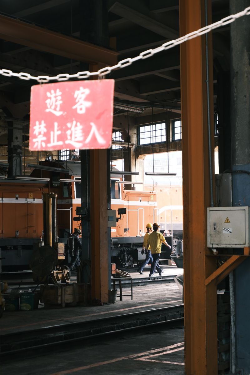 Workers in an industrial railway workshop with locomotives