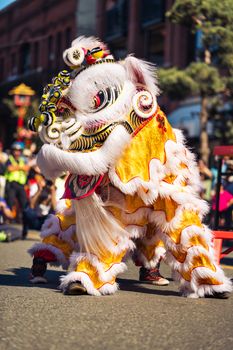 Colorful lion dance performance during a cultural parade in Victoria, BC, celebrating diversity.