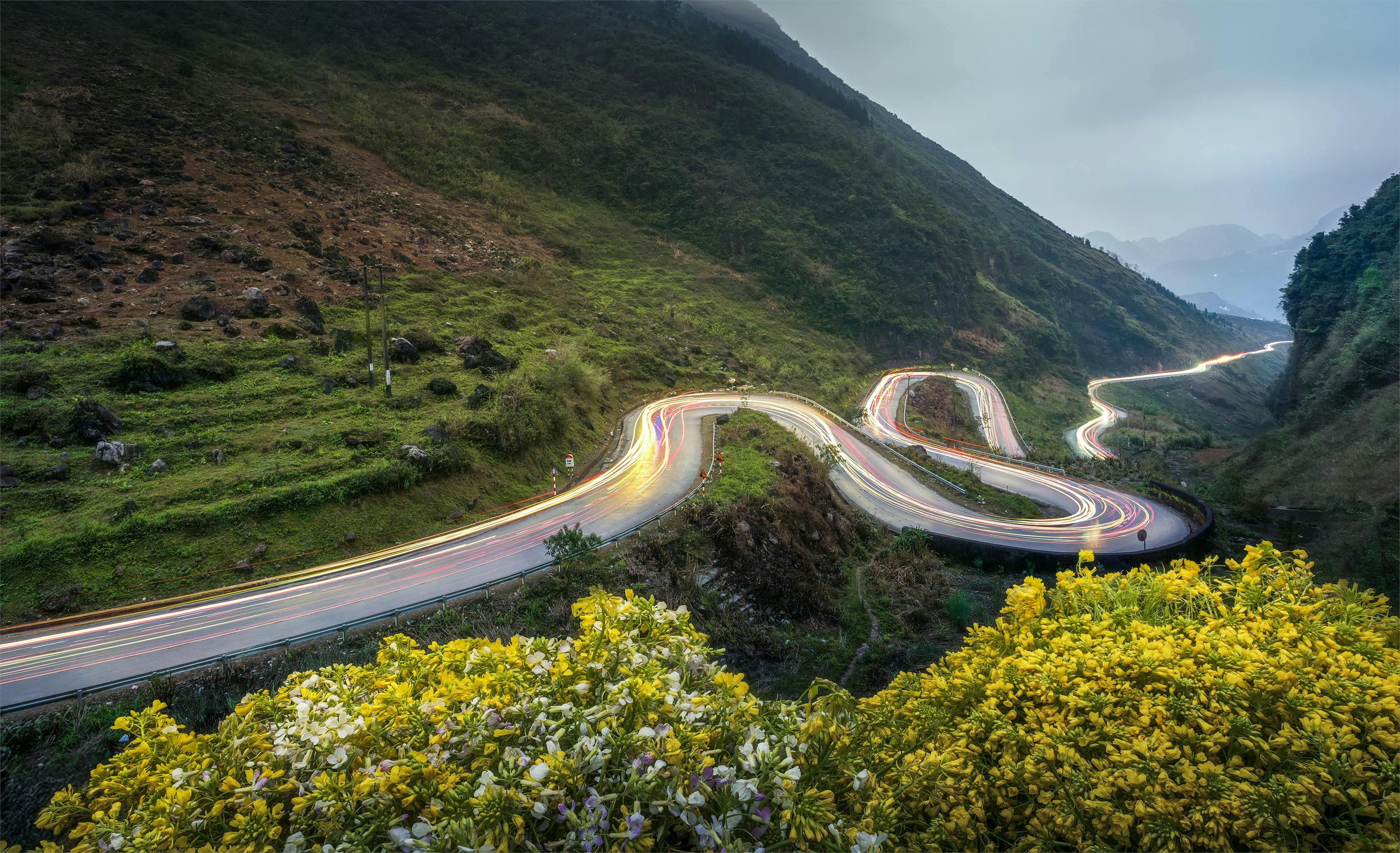A breathtaking view of a winding mountain road at night in Dong Van, Vietnam.