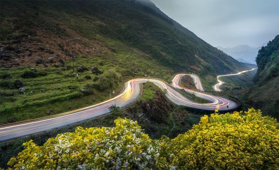 A breathtaking view of a winding mountain road at night in Dong Van, Vietnam.