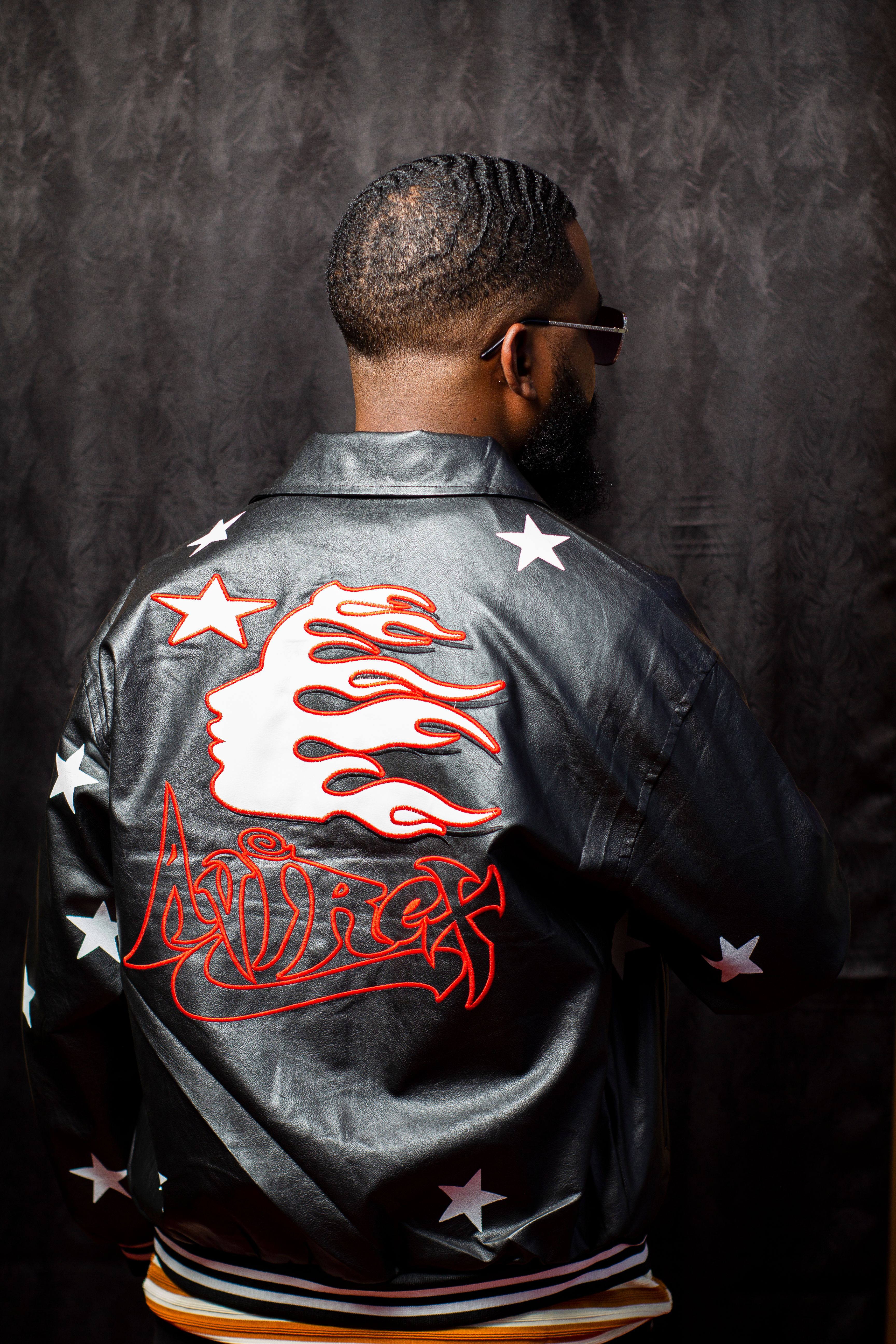 Rear view of man wearing a trendy jacket with flame and star designs, exuding modern fashion.