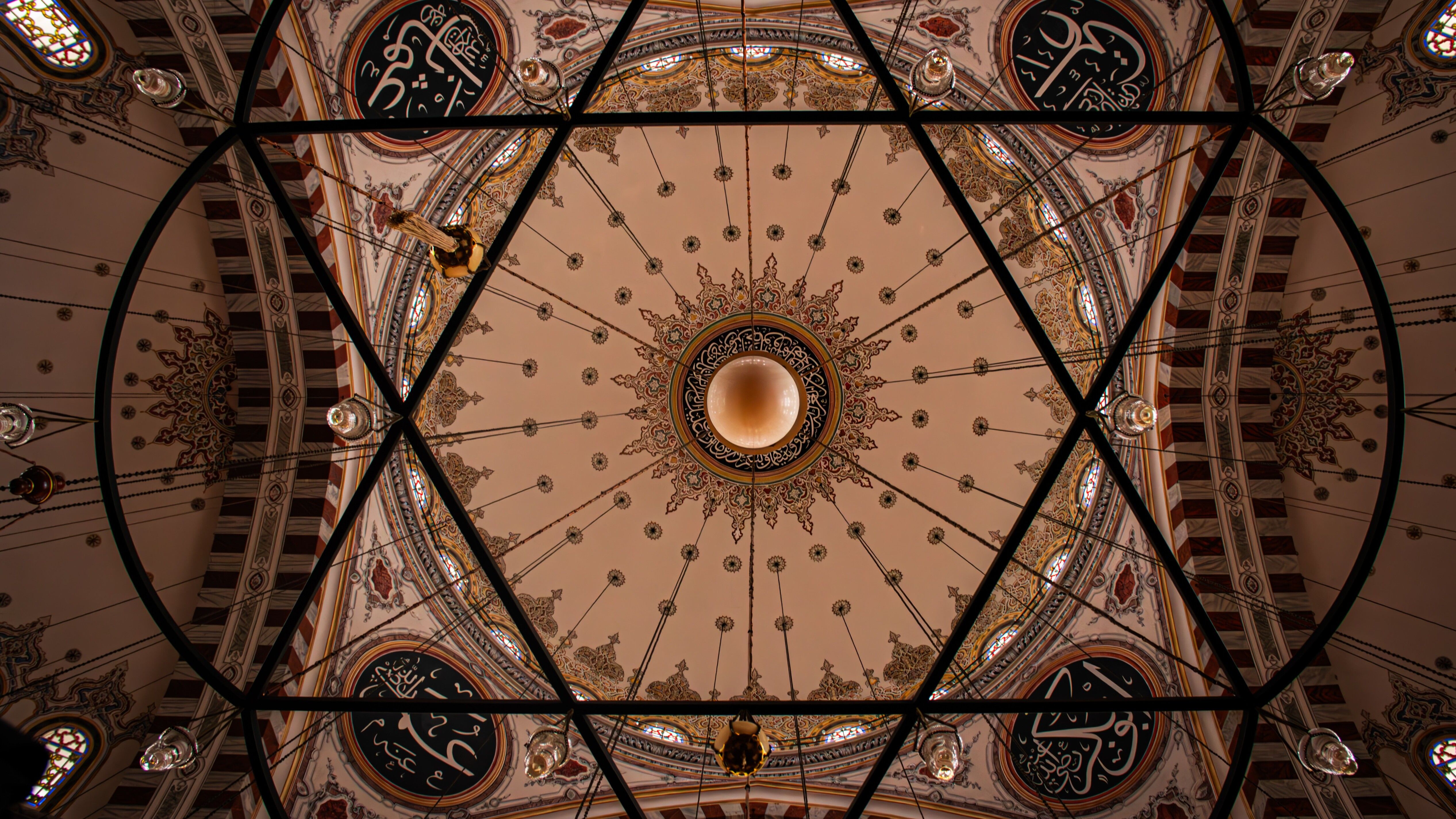Intricate ceiling design of İstanbul's Fatih Mosque with geometric patterns and Islamic calligraphy.